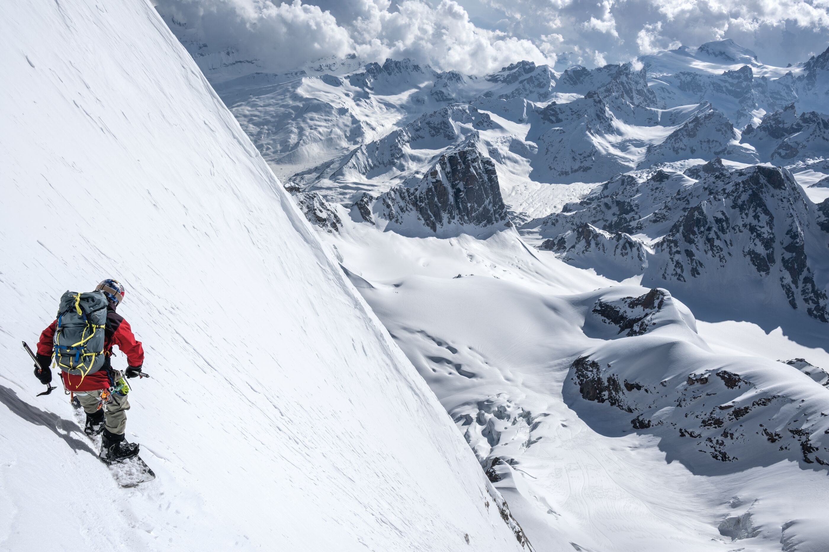 A person on a climb putting things in a backpack. 