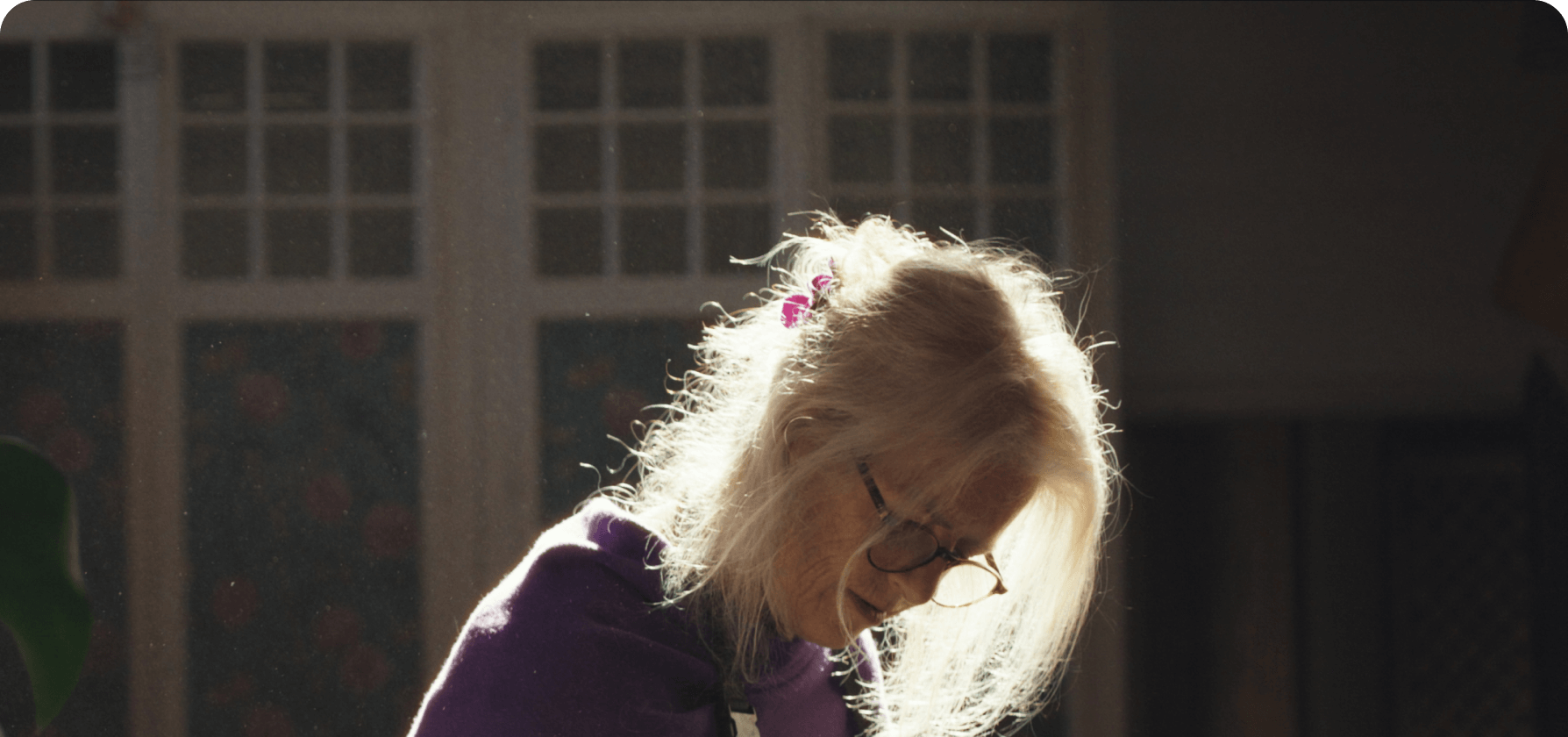 Anati Graetz carefully painting skis by hand at a workbench in a softly lit workshop.