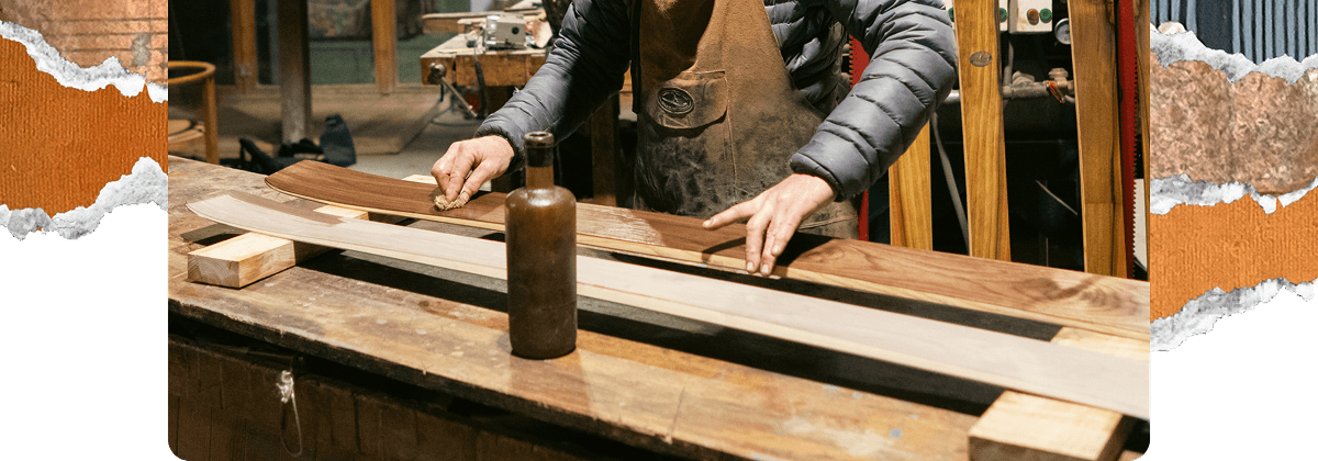 Peter Steltzner working at a wooden workbench, finishing skis in a workshop.